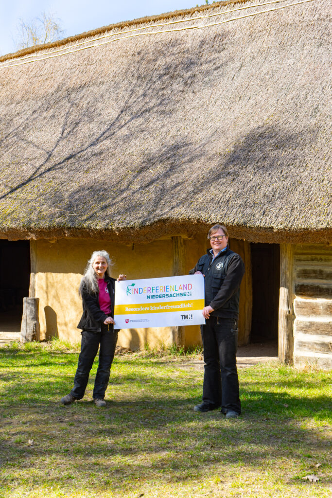 Ulli und Christoph mit dem Zertifizierungsplakat vor dem Langhaus Phönix